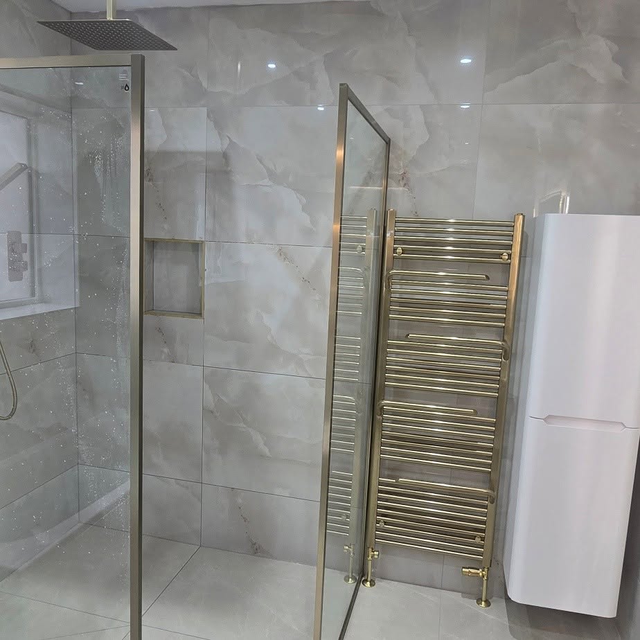 Shower enclosure, brass towel rail and a tall white storage unit