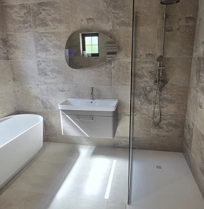 Freestanding bath, wall-hung basin and walk-in shower with marble-effect tiles