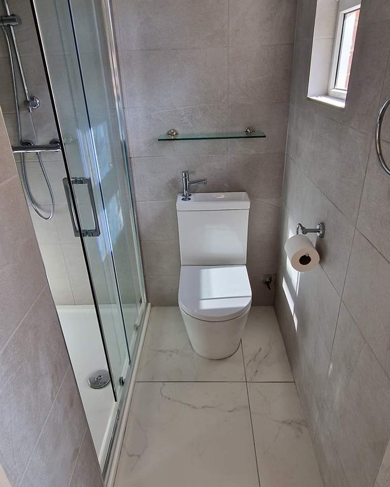 Walk-in shower enclosure and close-coupled toilet on a marble-effect floor