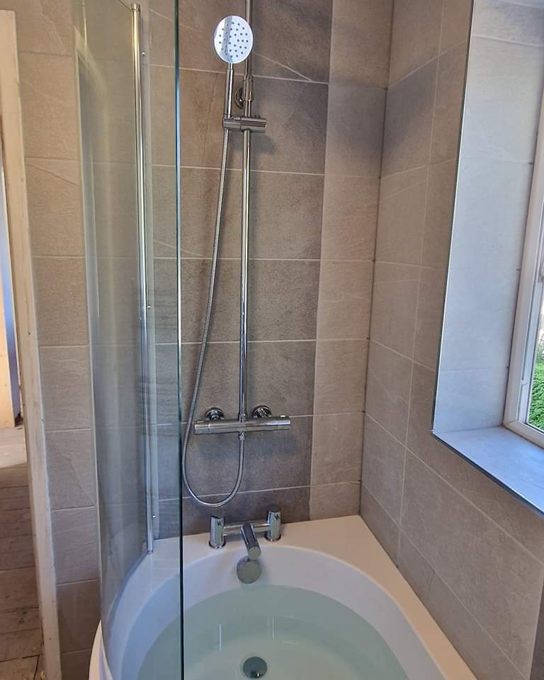 Shaped bath with a glass shower screen and thermostatic shower