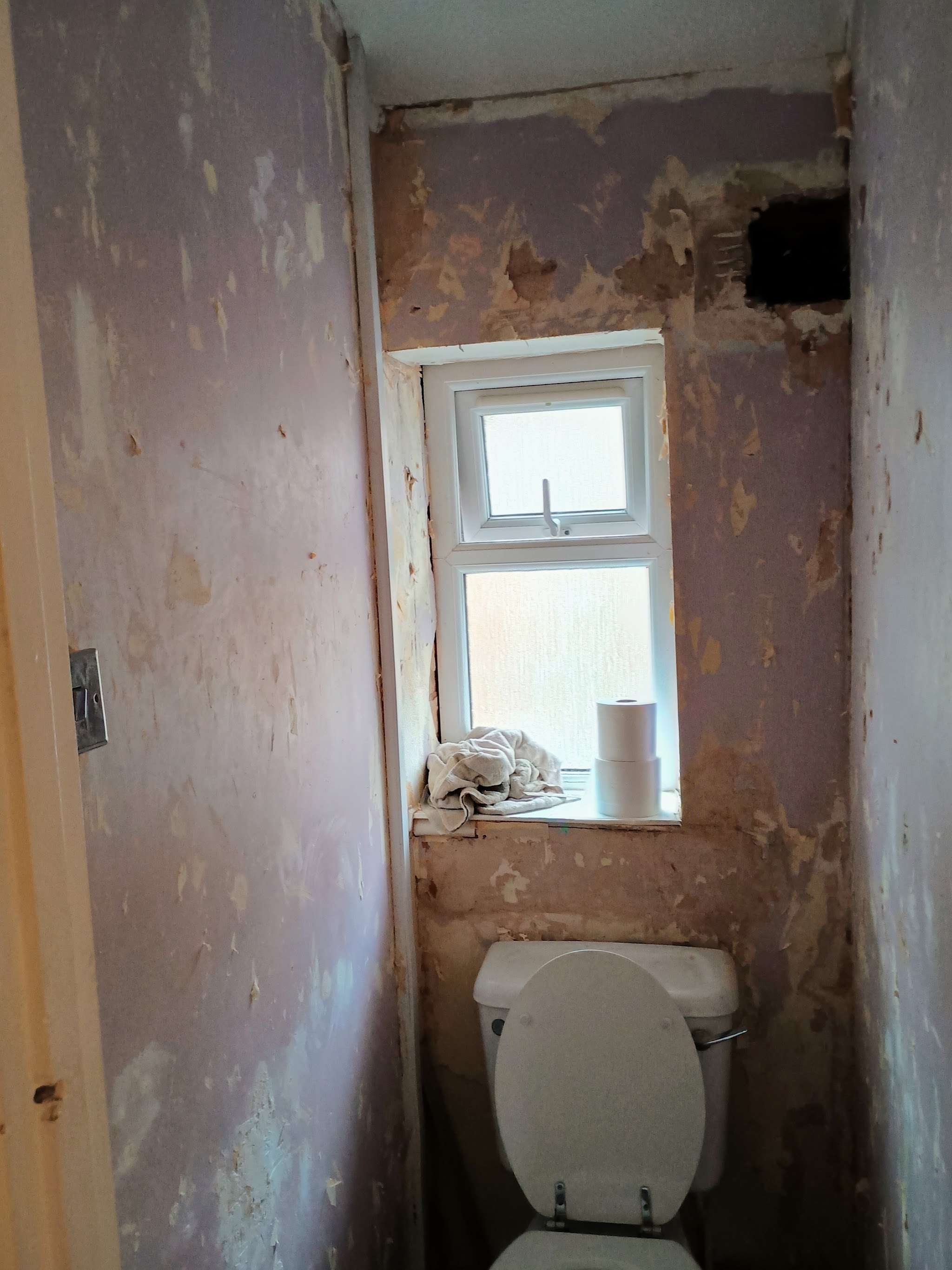 The same separate toilet before the refit, with the walls stripped back