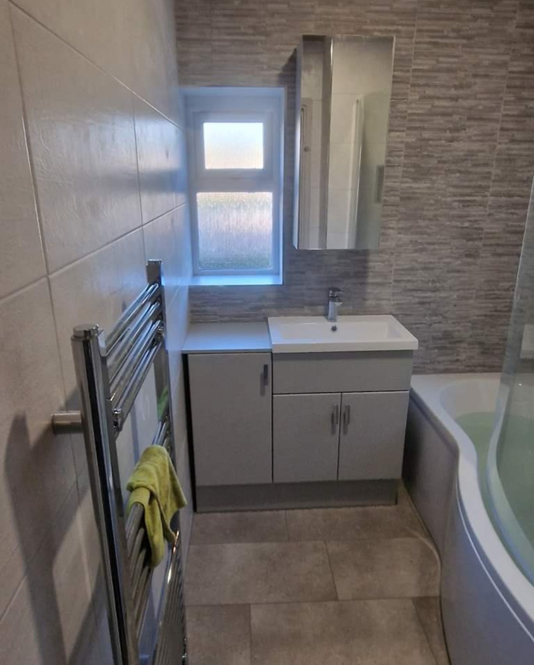 Grey vanity unit, mirror cabinet and chrome towel rail