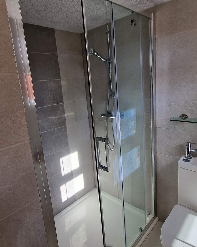 Glass shower enclosure with a slide-rail shower
